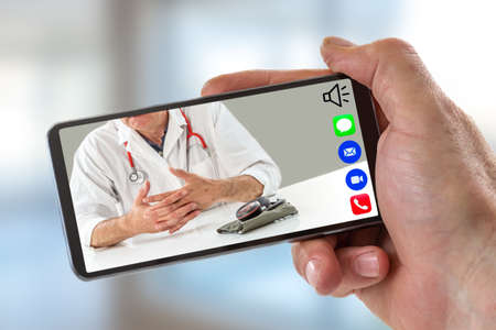 e-health: hand of a man holding Smartphone, mobile phone with calling icon in here,phone ,song,camera,and messaging,and live chat ith doctor on screen on whiteの写真素材