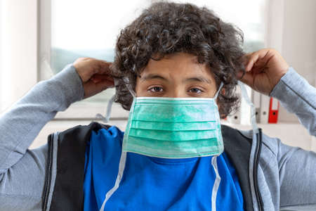 Coronavirus epidemic. boy holds a medical protective mask Face mask epidemic, flu. Coronavirus. Face mask for protection coronavirus outbreakの写真素材
