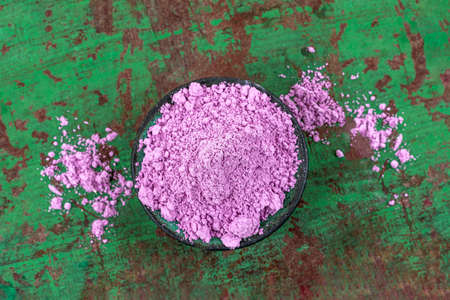 Dry pink clay powder mask for face and body in ceramic bowl isolated on wooden gezn backgroundの写真素材