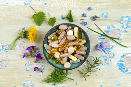 Evening primrose oil in a glass bowl, with fresh evening primrose flowers in the background