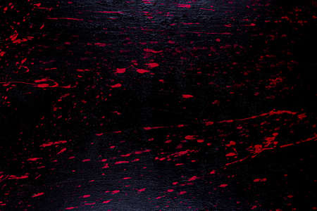 Red and black melted painted wooden board texture background.の写真素材