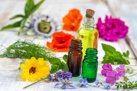 Lavender, rosemary, marigold and sage herbs in flower with an aromatherapy essential oil blue glass dropper bottleの写真素材