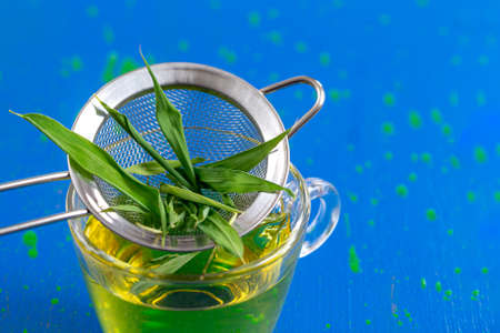 colander with drinking bamboo leaf tea in a glass cupの写真素材
