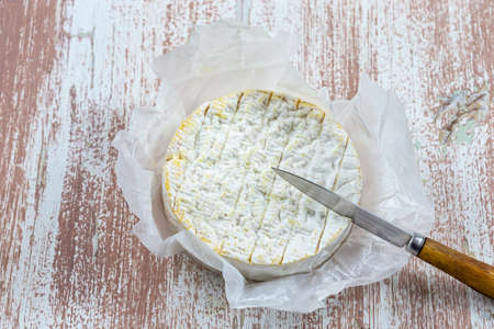 Soft French cheese Coulommiers, from cow milk and apples on wooden backgroundの写真素材