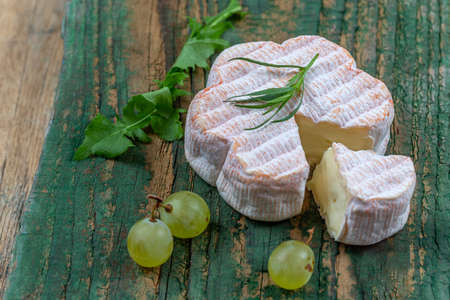 French Saint Albray cheese, slices on wooden cutting board, rustic style with grapesの写真素材