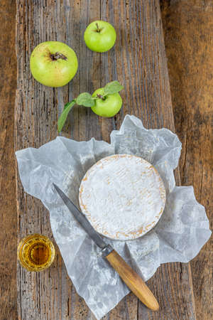 Sliced round camembert cheese traditional french milk creamy dairy product with fresh aromatics herbsの写真素材