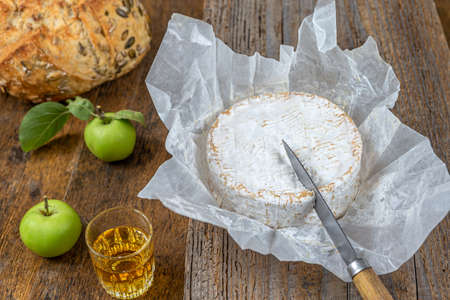 Sliced round camembert cheese traditional french milk creamy dairy product with fresh aromatics herbsの写真素材