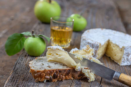 Sliced round camembert cheese traditional french milk creamy dairy product with fresh aromatics herbsの写真素材