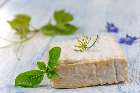 A block of Pont-l eveque French Normandy cheese resting on wooden boardの写真素材