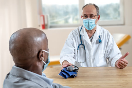Doctor meeting with African type patient, wearing protection maskの写真素材