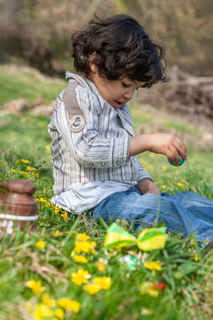 Little boy hunting for Easter egg in spring garden on Easter day.の写真素材