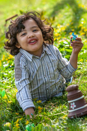Little boy hunting for Easter egg in spring garden on Easter day.の写真素材