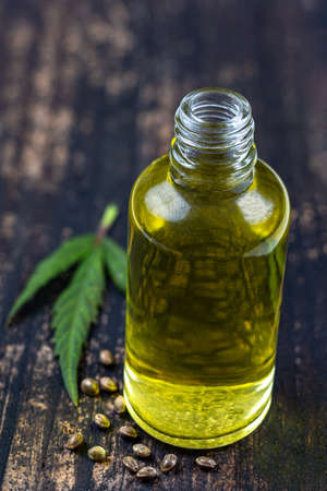 Organic hemp vegetable oil with leaf and seeds wooden backgroundの写真素材