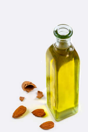 Bottled almond oil with almonds aroundの写真素材
