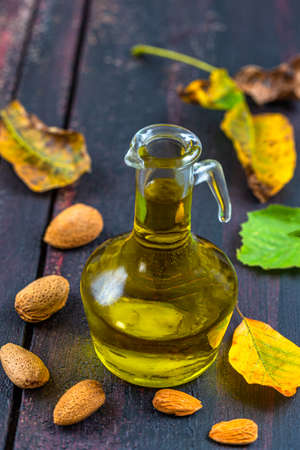 Bottled almond oil with almonds aroundの写真素材