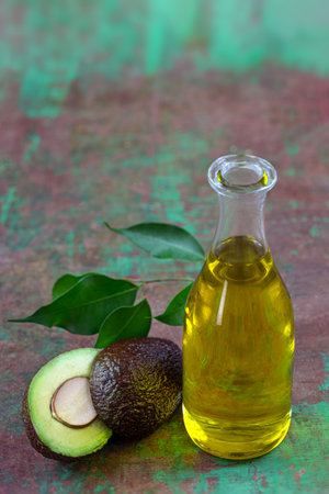 bottle of Avocado Vegetable Oil with fruit cut in halfの写真素材