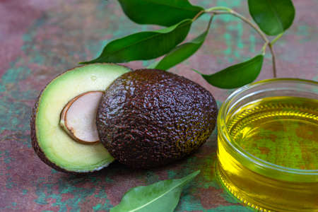 bottle of Avocado Vegetable Oil with fruit cut in halfの写真素材