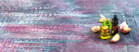 bottle of garlic essential oil surrounded by garlic cloves Panoramic view from aboveの写真素材