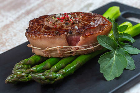 Asparagus tournedos on black dishの写真素材