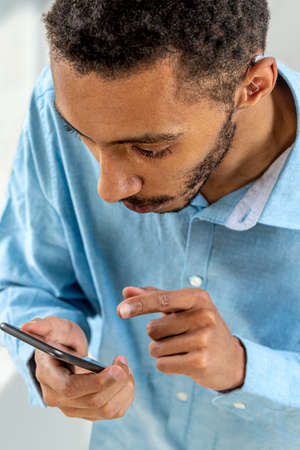 Digital Auditory-Settings with smartphone.Hearing disorders in a young man-Digital Auditory.の写真素材