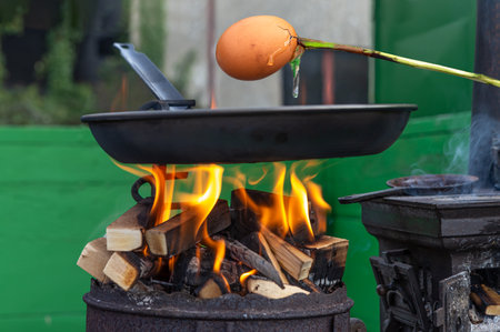Barbecue- Cooking egg on a skewer.の写真素材