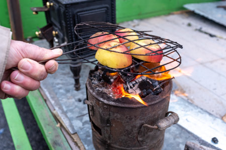 Apples cooking on a wooden stove on an old, vintage wood stove, in flamesの写真素材