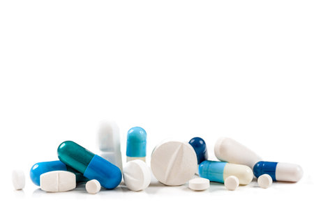 Blue capsules and hidden white in close-up on a cropped white background.の写真素材