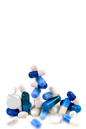 Blue capsules and hidden white in close-up on a cropped white background.の写真素材