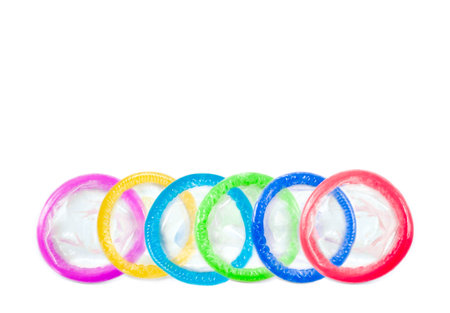 Public health,Condoms of various colors aligned on a white backgroundの写真素材