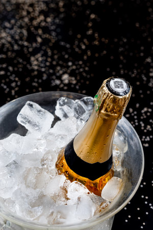 Bottle of Champagne in an ice bucket against a festive background and straw hutsの写真素材
