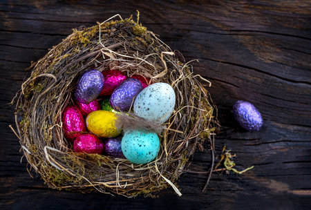 Multicolored Easter eggs in a nest seen from above.