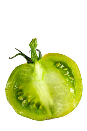 halved fresh green zebra tomato close up and tomatoes in the backgroundの写真素材
