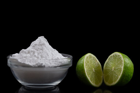 Baking soda, vinegar and cut lemons on blac bacgrondtable, flat lay. Space for textの写真素材