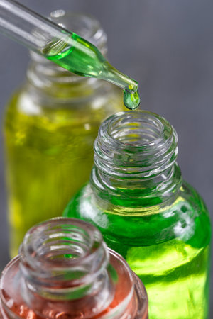 essential oil falling from glass dropper profile viewの写真素材