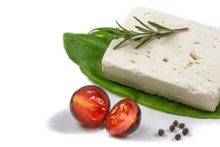 Wole Feta cheese isolated on white background clipping Heap of Feta cheese, basil leaves and tomatoes.の写真素材