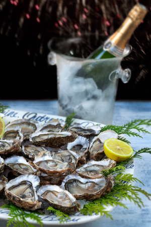 A dish with oysters on a table with festive decor and champagne botle. Christmas celebration. Close-up.の写真素材