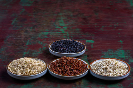 Variety of types and colours of rice - red, black, basmati, whole grain, long grain on dark wooden backgroundの写真素材