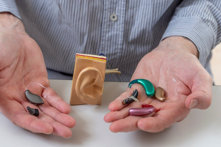Different types of hearing aids displayed in hands
