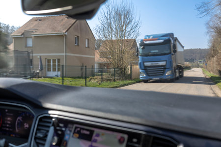 Truck navigating a rural road beside housesの写真素材