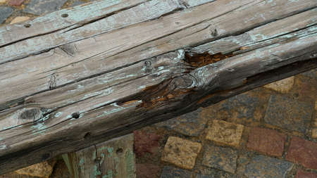 the appearance of an old, decaying wooden bench with paint peeling and rotting.の写真素材