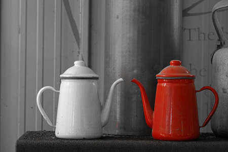 a white kettle and a red kettleの写真素材