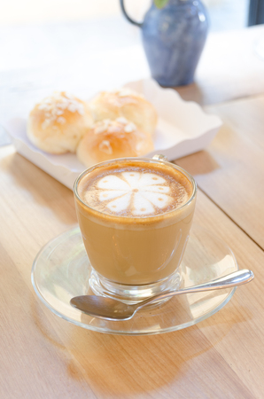 A cup of coffee on wooden background, latte artの写真素材