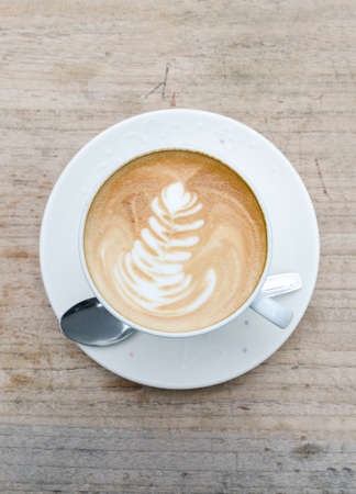 Cup of hot coffee latte art on wood tableの写真素材