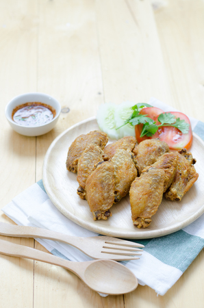 Fired chicken wing on wood plate with thai dipの写真素材