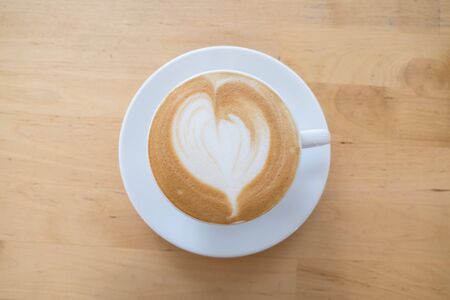 Cup of hot coffee latte art on wood tableの写真素材