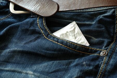 Condom in the blue jeans. Focus on the condom.