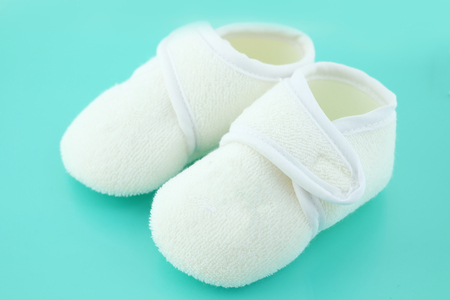 Baby shoes on light blue backgroundの写真素材
