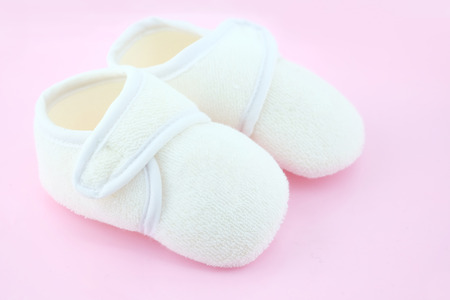 Baby shoes on light pink backgroundの写真素材