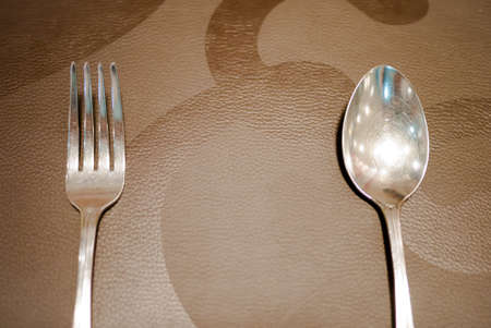 fork and knife placed on brown texture  able to use as backgroundの写真素材