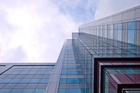 High and glassy office building, from the worm eyes view, showing an interesting reflection のeditorial素材